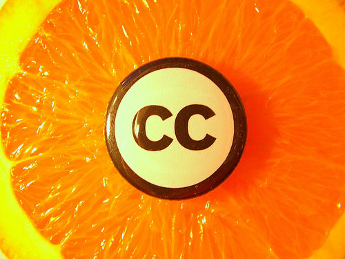 The Creative Commons logo on an orange fruit background  